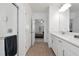 Bright bathroom boasts double vanity, walk-in shower, and view to bedroom at 17322 Holly Well Ave, Wimauma, FL 33598