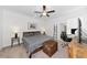 Main bedroom with gray bedding, a workspace, and a ceiling fan at 17322 Holly Well Ave, Wimauma, FL 33598