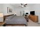 Main bedroom with gray bedding, a workspace, and a ceiling fan at 17322 Holly Well Ave, Wimauma, FL 33598