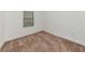 Simple carpeted bedroom with neutral walls and a window at 17322 Holly Well Ave, Wimauma, FL 33598