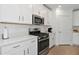 Modern kitchen with white cabinets, stainless steel appliances and quartz countertops at 17322 Holly Well Ave, Wimauma, FL 33598