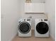 Practical laundry room with washer, dryer, and overhead cabinets at 17322 Holly Well Ave, Wimauma, FL 33598