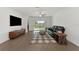 Living room with hardwood floors, a black leather sofa, and sliding glass doors at 17322 Holly Well Ave, Wimauma, FL 33598
