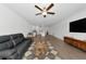 Open concept living room with kitchen view, hardwood floors, and gray couch at 17322 Holly Well Ave, Wimauma, FL 33598