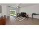Living room with hardwood floors, a black leather sofa, and sliding glass doors at 17322 Holly Well Ave, Wimauma, FL 33598