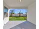 Covered patio overlooks a fenced backyard with grassy lawn at 17322 Holly Well Ave, Wimauma, FL 33598