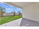 Covered patio overlooks a fenced backyard with grassy lawn at 17322 Holly Well Ave, Wimauma, FL 33598