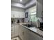 Modern kitchen with white cabinets, granite countertops, and a stylish sink at 2220 Stickney Point Rd # 537, Sarasota, FL 34231