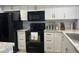Modern kitchen with black appliances and white shaker cabinets at 2220 Stickney Point Rd # 537, Sarasota, FL 34231