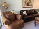Living room with brown corduroy armchair and leather sofa at 2220 Stickney Point Rd # 537, Sarasota, FL 34231