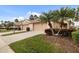 Tan house with two-car garage and landscaped yard at 288 Fairway Isles Ln, Bradenton, FL 34212