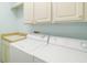 Bright laundry room with washer, dryer, and cabinets at 288 Fairway Isles Ln, Bradenton, FL 34212