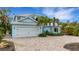 Two-story light blue house with white garage and brick driveway at 3532 Flamingo Ave, Sarasota, FL 34242