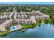Aerial view of a condo community with pool, lake, and parking at 3544 Lake Bayshore Dr # K123, Bradenton, FL 34205