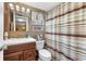 Bathroom with striped shower curtain, toilet and vanity at 3544 Lake Bayshore Dr # K123, Bradenton, FL 34205