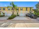 Front view of a yellow townhome with garage and driveway at 3810 82Nd Avenue E Cir # 102, Sarasota, FL 34243