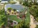 Aerial view showcasing a yellow house with a heart-shaped garden and palm trees at 3972 Titan St, North Port, FL 34286