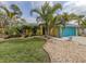 Bright yellow house with teal garage door, landscaping, and palm trees at 3972 Titan St, North Port, FL 34286