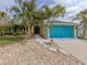 Front view of a yellow house with teal garage door and palm trees at 3972 Titan St, North Port, FL 34286