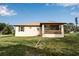Back of house with screened porch and grassy yard at 4310 Zenith Rd, Venice, FL 34293