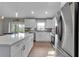 Modern kitchen with white cabinets, stainless steel appliances, and a large island at 4310 Zenith Rd, Venice, FL 34293
