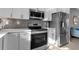 Modern kitchen features stainless steel appliances and gray chevron backsplash at 4310 Zenith Rd, Venice, FL 34293