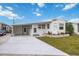Front view of a white mobile home with carport, landscaping, and driveway at 4953 Sea Island Ave, Sarasota, FL 34234