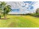 Landscaped backyard with lush grass and a serene view of a pond at 5023 Tobermory Way, Bradenton, FL 34211