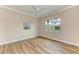 Bright bedroom with wood-look flooring, ceiling fan, and large window at 5023 Tobermory Way, Bradenton, FL 34211