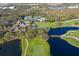 Aerial view of golf course, clubhouse, and a pond with bridge at 5318 88Th E St, Bradenton, FL 34211