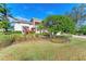 Landscaped front yard with manicured shrubs and a large tree at 5318 88Th E St, Bradenton, FL 34211
