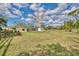 Large, grassy backyard with a view of the home, shed, and partial fencing at 5515 Richardson Rd, Sarasota, FL 34232