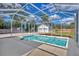 Backyard pool area with a screened enclosure and a detached garage with a two-car garage and a well-maintained lawn at 5515 Richardson Rd, Sarasota, FL 34232