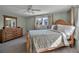 Bright bedroom with wood post bed, dresser, and ceiling fan at 5708 Miami Rd, Venice, FL 34293
