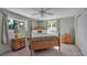 Bedroom with wood post bed, ceiling fan, and window views at 5708 Miami Rd, Venice, FL 34293