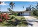 Tan single story home with a large yard, palm trees, and a two-car garage at 5708 Miami Rd, Venice, FL 34293