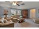 Bright living room with light beige sofas, wood coffee table, and large windows at 5708 Miami Rd, Venice, FL 34293