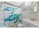 Clean bathroom with a shower/tub combo, white vanity, and sea turtle shower curtain at 5806 15Th W St, Bradenton, FL 34207