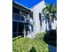 Side view of a light blue condo building with balcony and lush landscaping at 6707 Stone River Rd # 203, Bradenton, FL 34203
