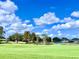 Peaceful golf course view with mature trees and pond at 6707 Stone River Rd # 203, Bradenton, FL 34203