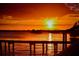 Stunning sunset over calm water with dock and distant houses at 6707 Stone River Rd # 203, Bradenton, FL 34203