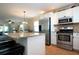 Open kitchen with stainless steel appliances, granite countertops, and white cabinets at 804 Buttonwood Dr, Bradenton, FL 34208