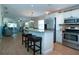 Open concept kitchen island with seating, stainless steel appliances, and wood-look floors at 804 Buttonwood Dr, Bradenton, FL 34208