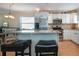Kitchen island with granite countertop and seating, stainless steel appliances, and white cabinets at 804 Buttonwood Dr, Bradenton, FL 34208