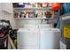 Bright laundry room with washer, dryer, and storage shelves at 804 Buttonwood Dr, Bradenton, FL 34208