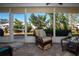 Relaxing screened porch with wicker furniture, overlooking a lush green backyard at 804 Buttonwood Dr, Bradenton, FL 34208