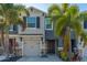 Two-story townhome with gray siding, two-car garage, and palm trees at 8655 Stargazer St, Sarasota, FL 34238