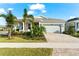 One-story home with light gray exterior, landscaping, and paver driveway at 8725 Sundance Loop, Sarasota, FL 34238