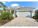 House exterior featuring a light gray color, paver driveway, and landscaping at 8725 Sundance Loop, Sarasota, FL 34238