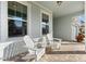 Relaxing front porch with two white adirondack chairs at 8725 Sundance Loop, Sarasota, FL 34238